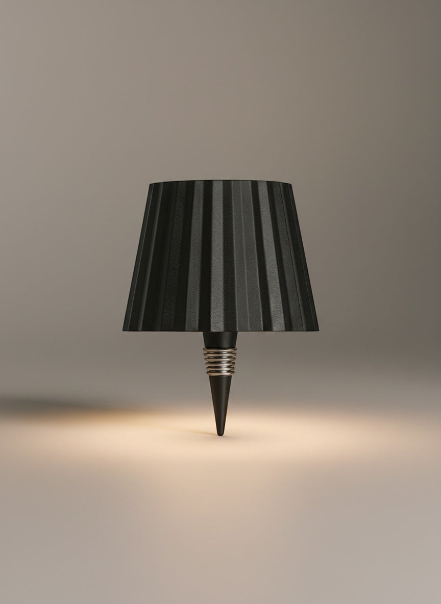 Vinlume black textured bottle lamp with pleated shade and silver spring detail, casting a warm glow.